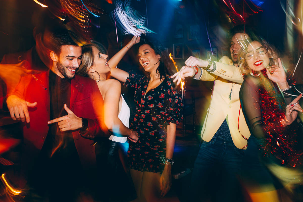 eine Gruppe aus 5 Freunden tanzt ausgelassen auf einer Party