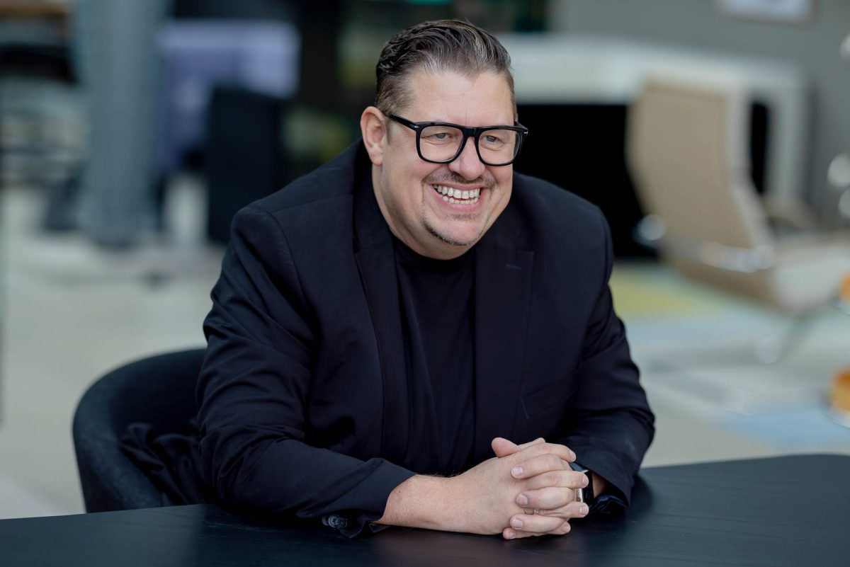 For the portrait photo, DJ Frank is sitting at a black table