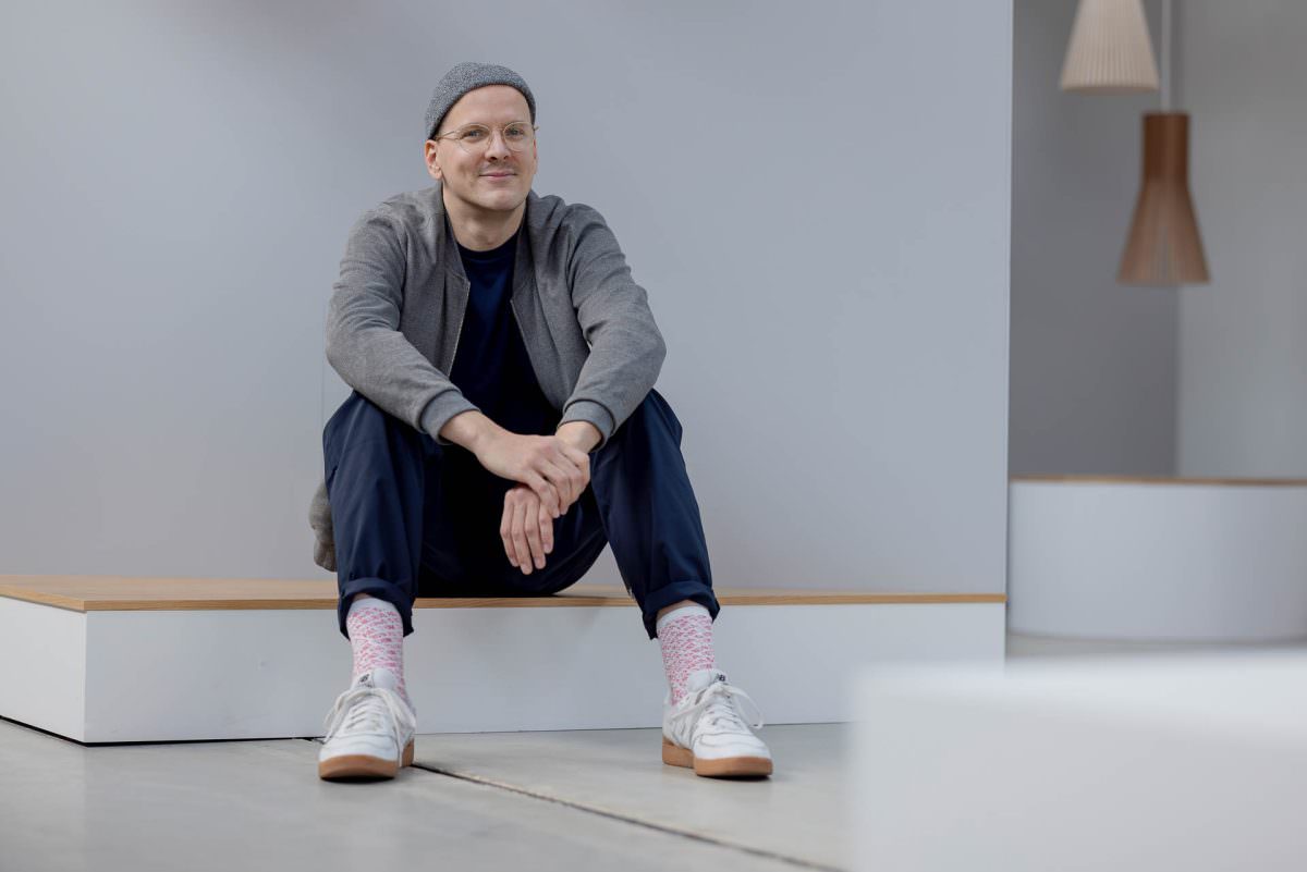 Portrait photo of DJ Phil sitting on a small riser