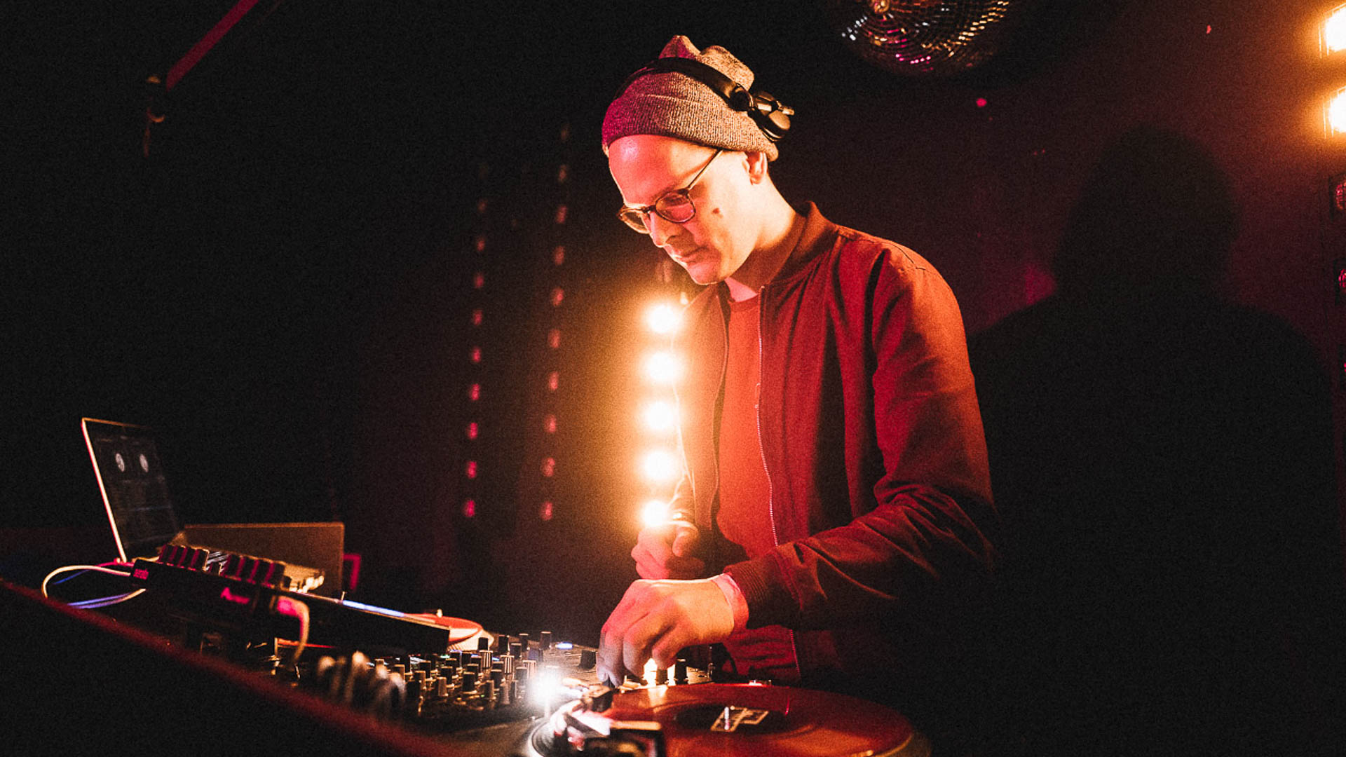 DJ Phil operates the controls at his DJ booth at a party.