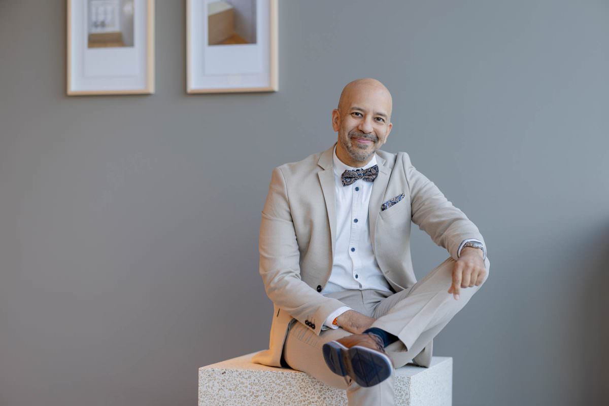 Portrait of DJ Viru sitting on a square stool