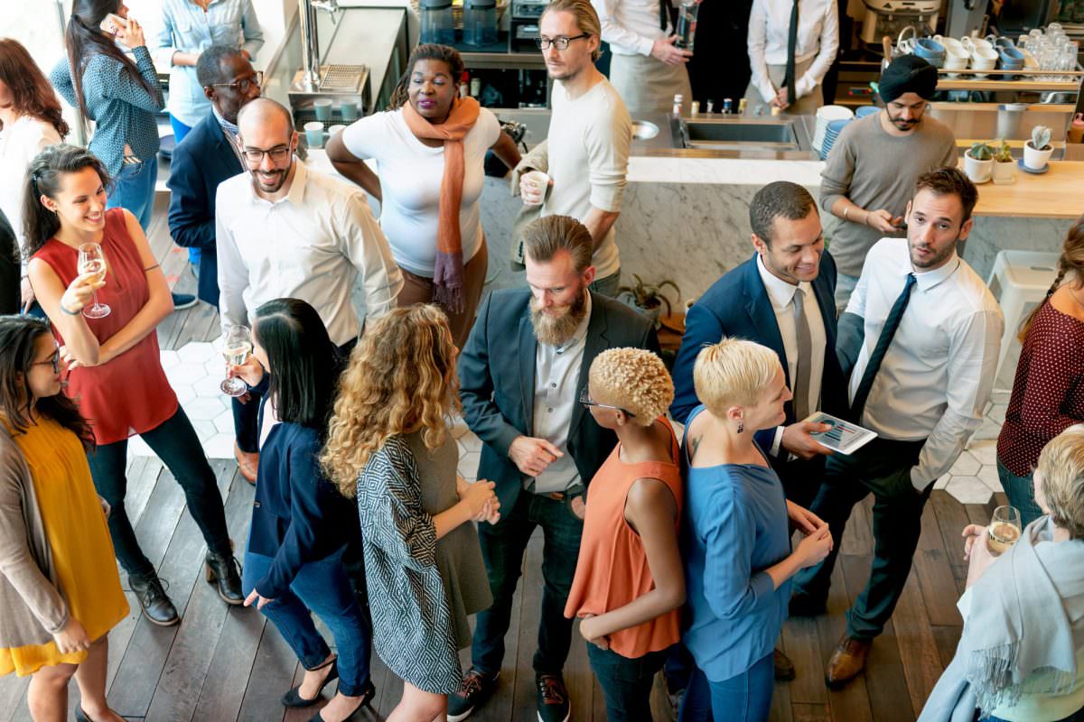 Party guests stand together in a bar and chat