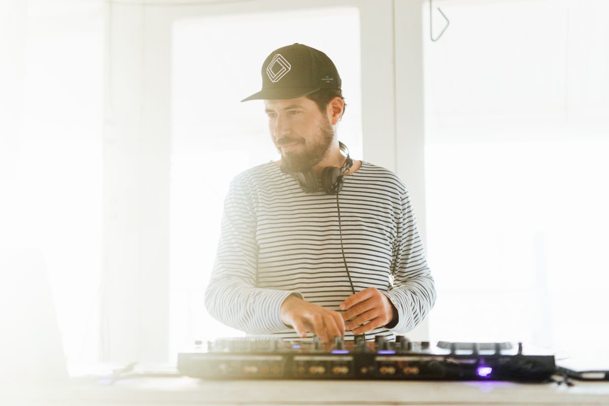 Event DJ Markus Rosenbaum at his DJ booth with durable, high-quality equipment for sustainable events.