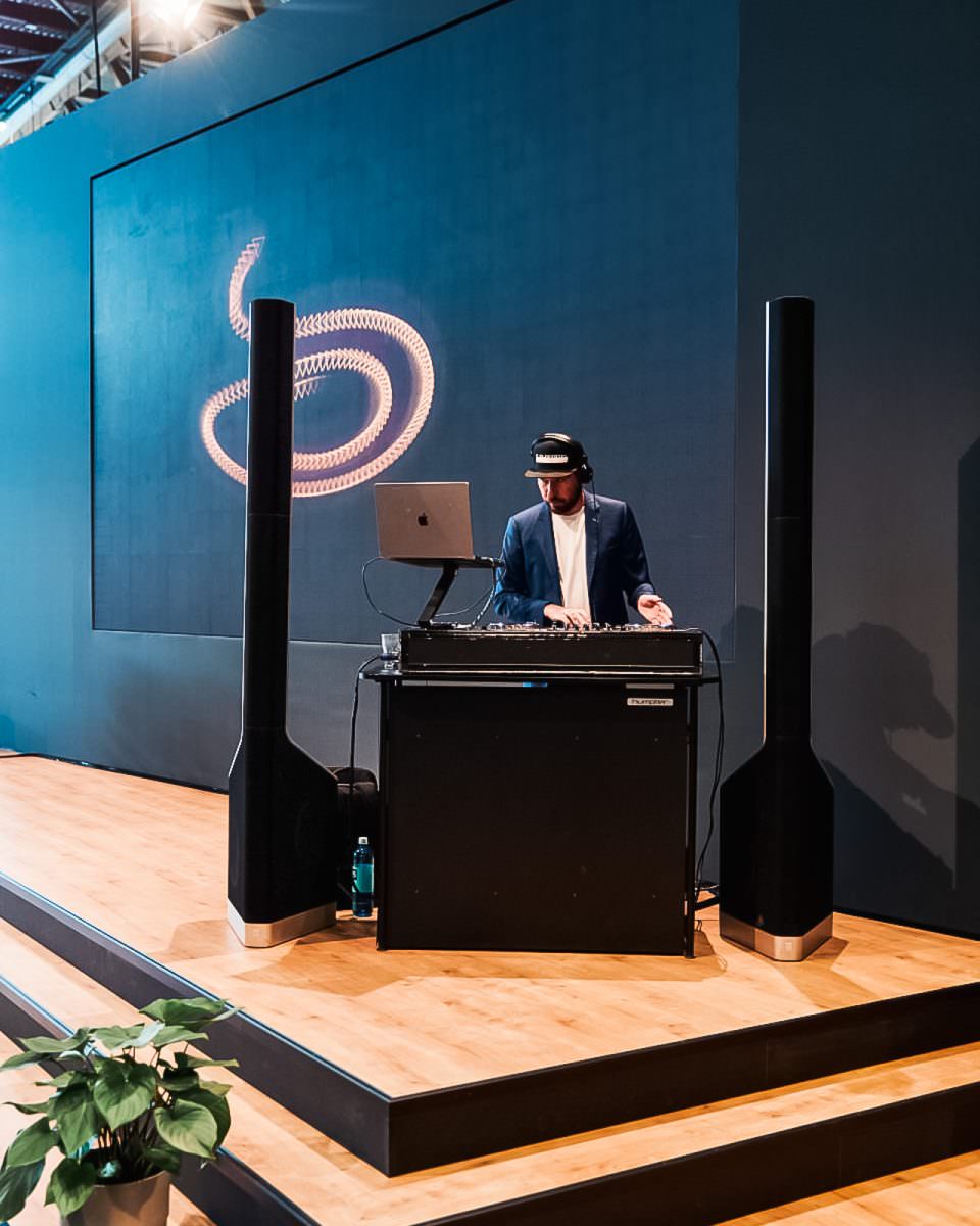 Event-DJ Markus Rosenbaum steht auf der Altenpflege Messe hinter seinem DJ-Pult.