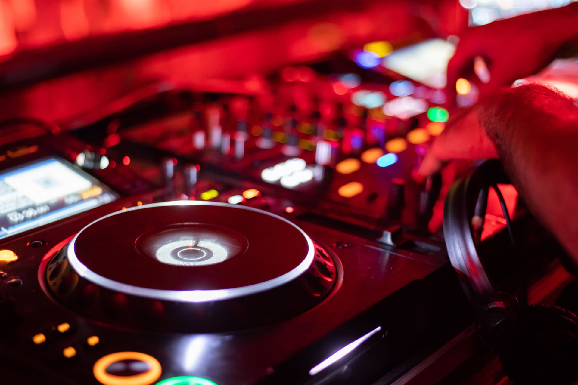 Professionelles DJ-Entertainment auf einer Messestand-Party: Event-DJ bei der Arbeit am Pult.