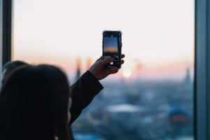 The visitor at an after-trade-fair event in KölnSKY photographs the view with her mobile phone.