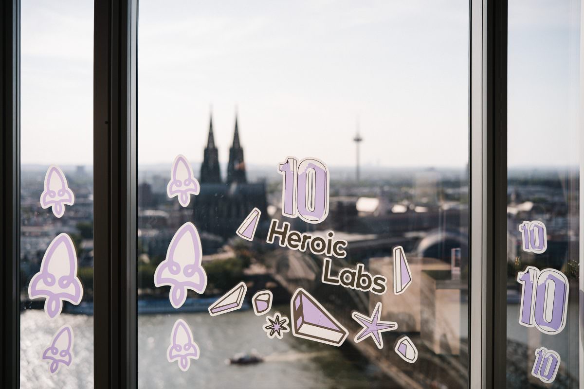 Heroic Labs logo as a window sticker at an event in KölnSKY with Cologne Cathedral in the background.