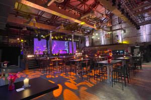 Seating with high tables and bar stools in the festival hall of the soap factory – ideal for networking and company events with a DJ.