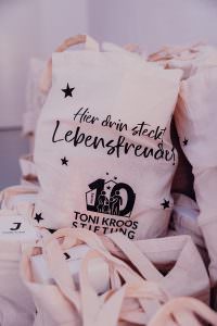 Sustainable giveaways: Cloth bags with the 10 Years Toni Kroos Foundation logo for guests of the anniversary celebration at the Lofthaus.