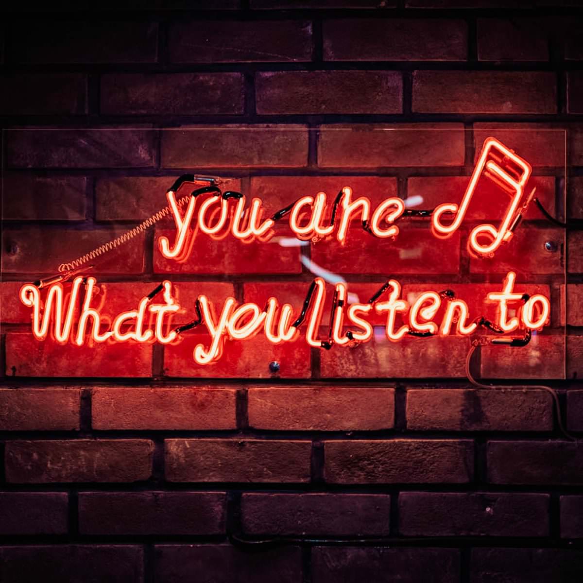 glowing neon sign you are what you listen to with musical note