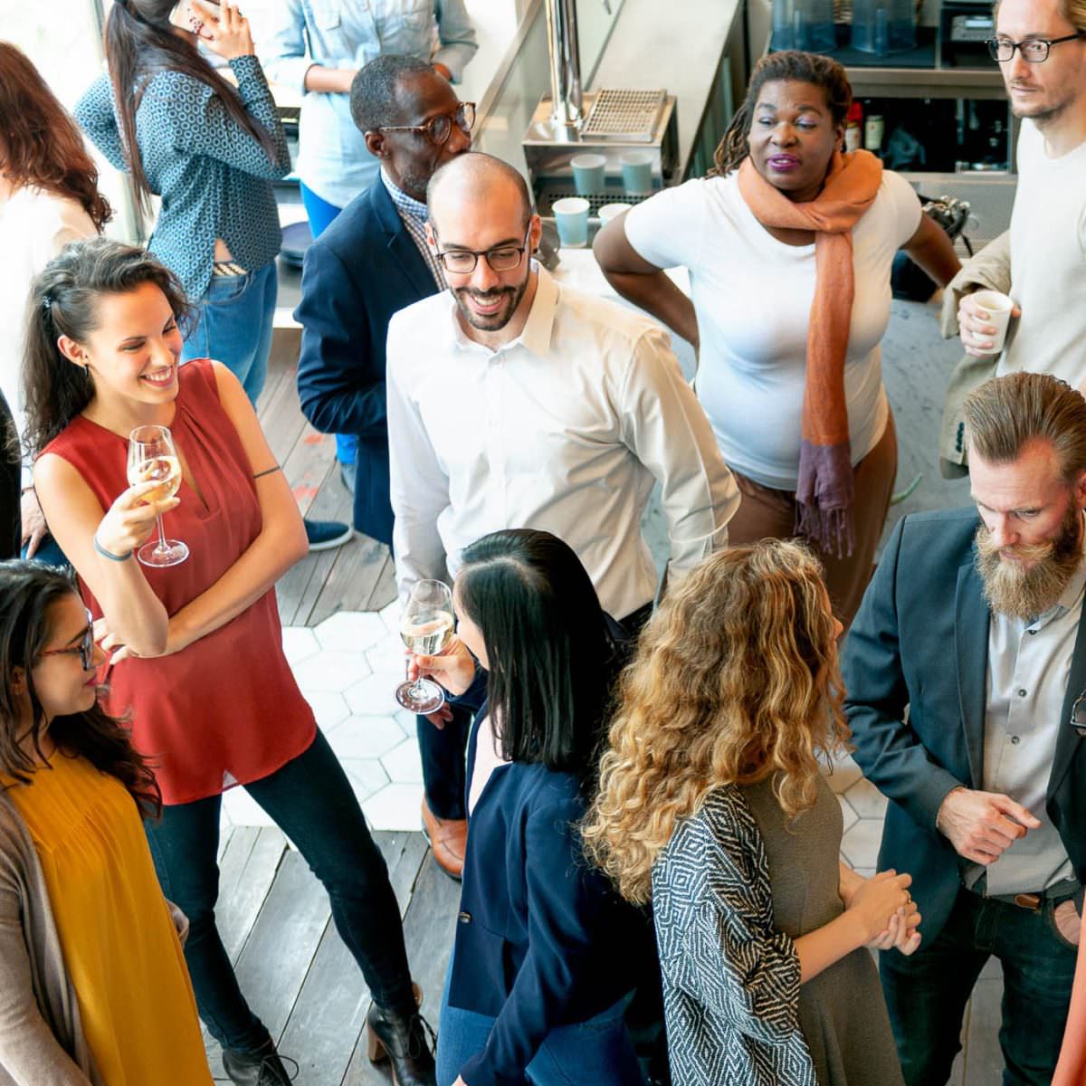 Party guests stand together in a bar and chat