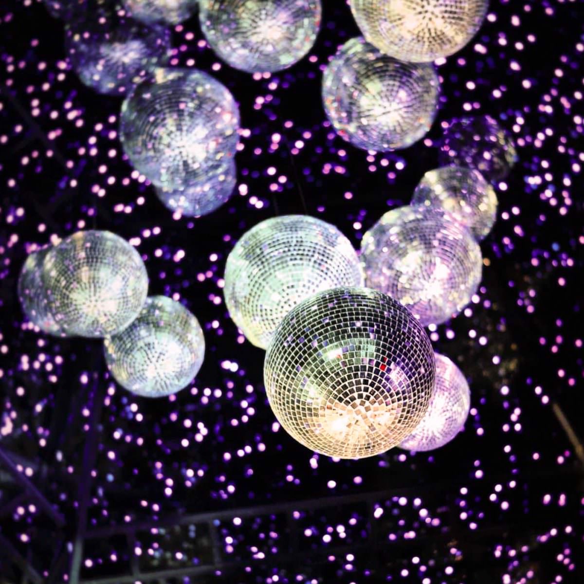 mehrere Discokugeln und kleine Lichter an der Decke einer Event Location