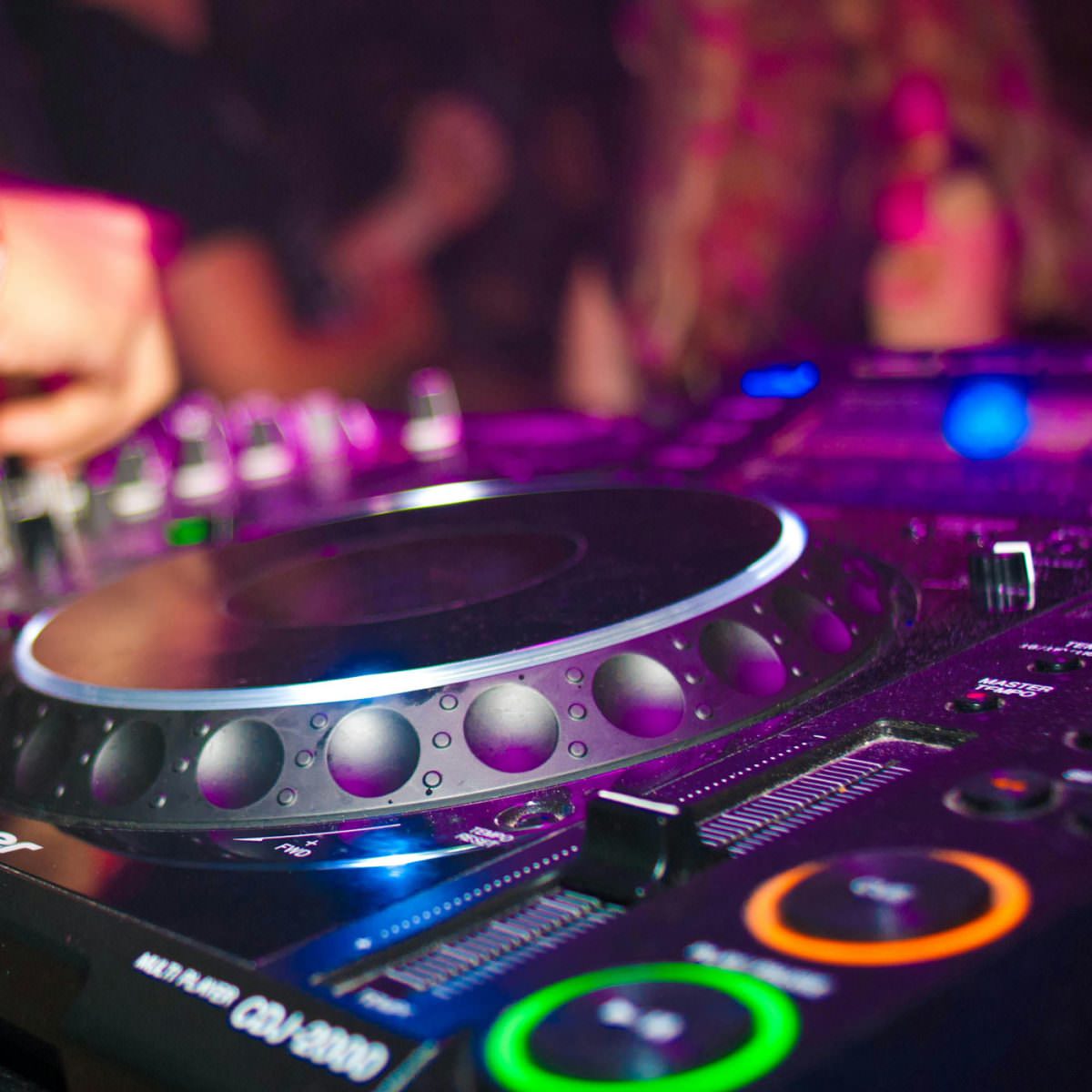Close-up of a Pioneer DJ controller with a DJ adjusting the knobs