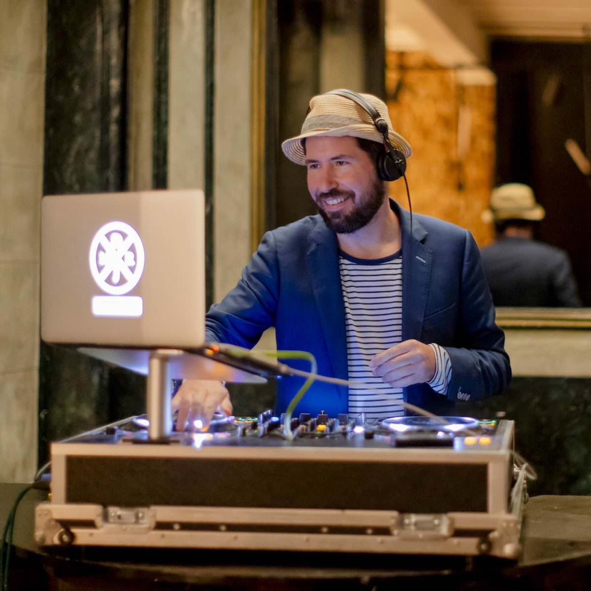 auf einem Event trägt DJ Markus Rosenbaum Headphones und bedient die Regler seines Mischpults